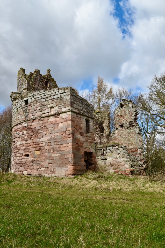 Photo taken facing the south wall and missing east wall. D-shaped military wall is on the left. Height of structure greater on left, but upper floors are missing.