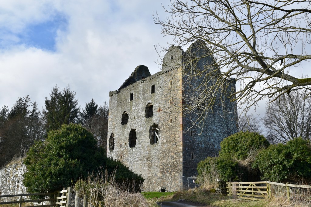 
Tower, nestled among the trees and bushes. Lage holes where windows were located. Roff missing but gables visible. 