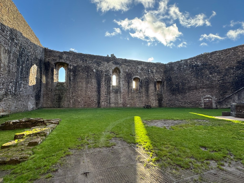 view of grassed courtyard looking towards the curtain walls on three sides of the castle.
