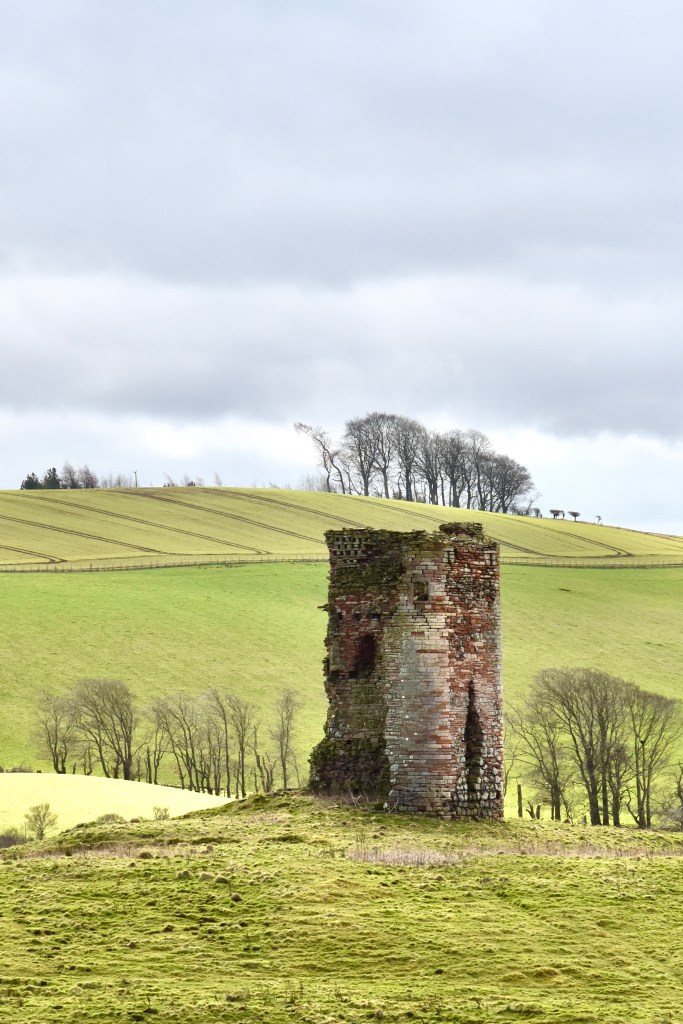 Distant view of Corsbie Tower, from north. showing gently sloping hills in the background.