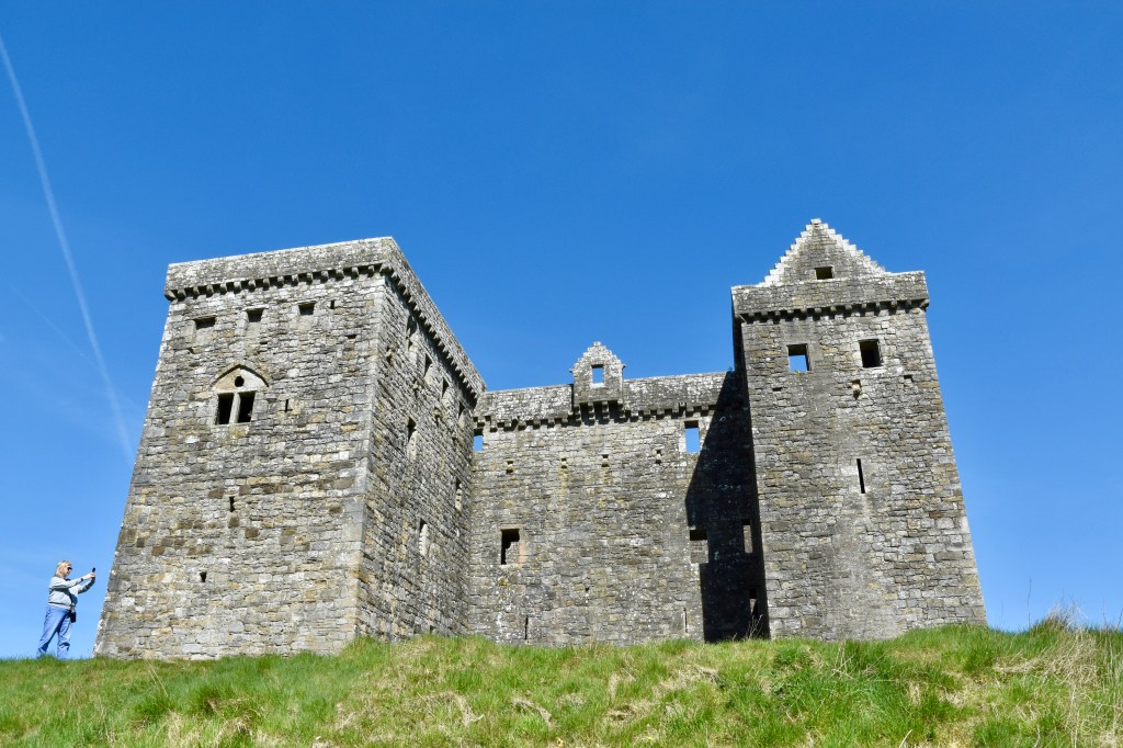 View looking up at castle from the south. Two towers stick out at corners.