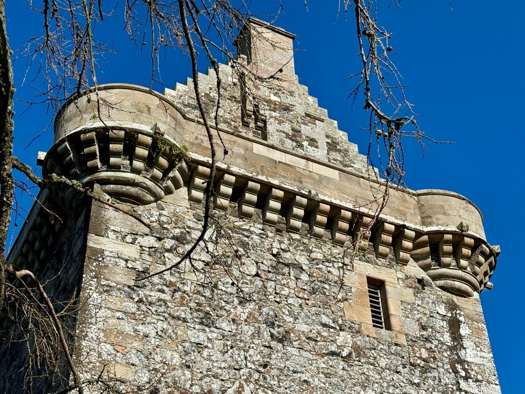 Close up of the parapet, showing the regular repeated corralling around the corner turrets and along the top wall.