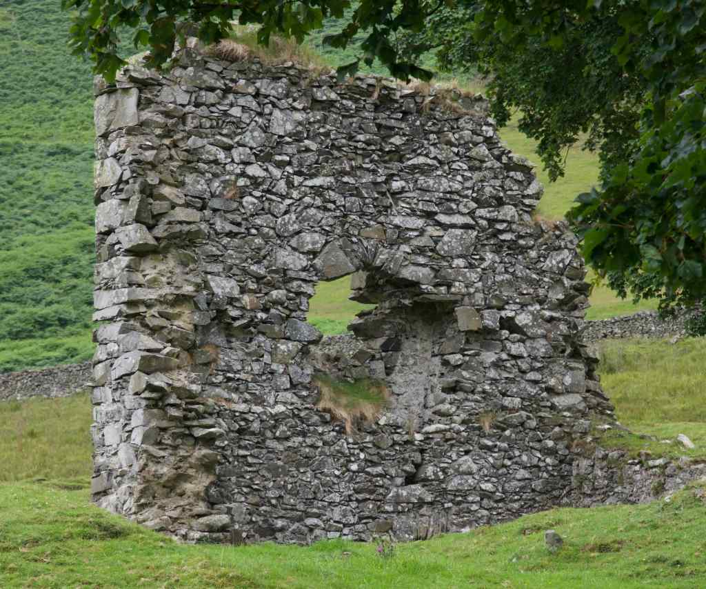 Close-up of the outbuilding wall. The jagged and damaged edges are apparent.