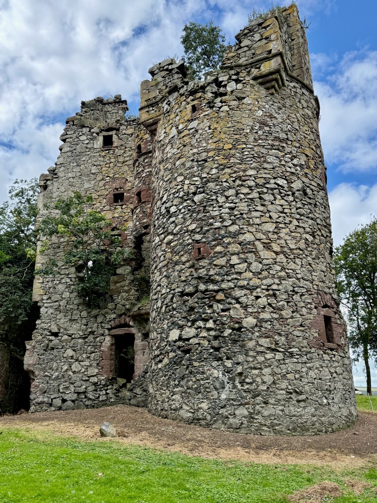 Close-up of the near complete circular tower, showing gun loops and larger windows, dressed with red sandstone