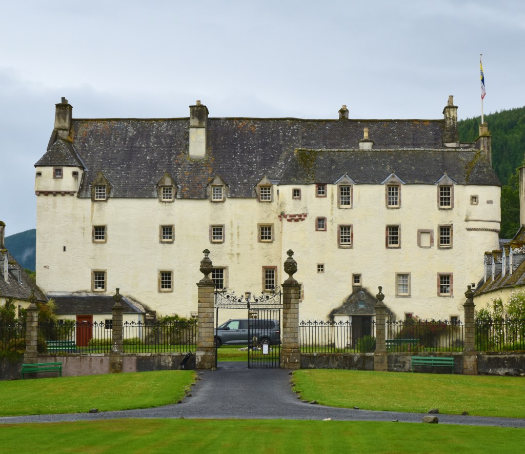 Front view of main block of house. Grassed area in front. White-harled facade with grey roof.