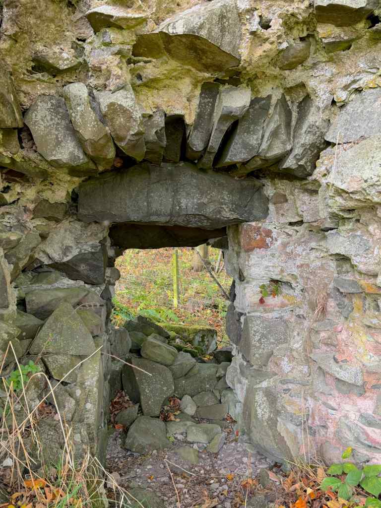 close-up of the window or opening in the castle wall. Jagged, weathered, grey stone with hints of pink sandstone.