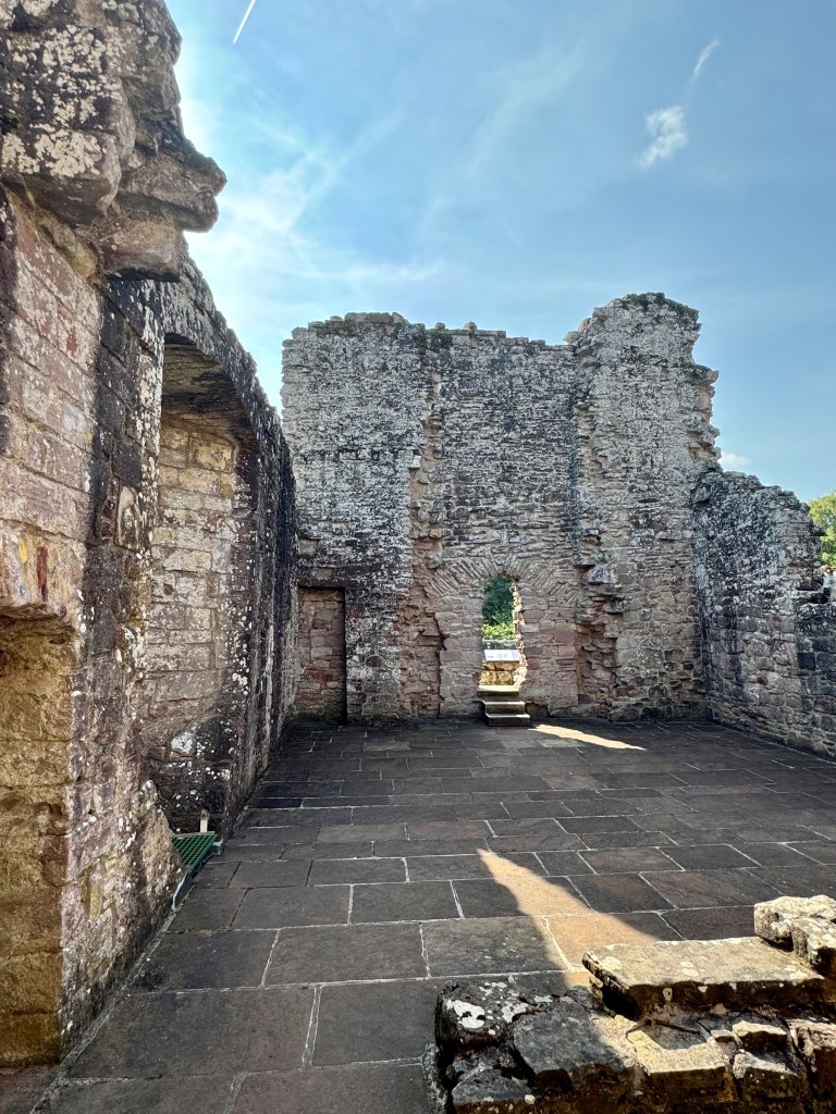 Roofless part of abbey, with badly damaged rear and side walls. Paved floor (probably not original)