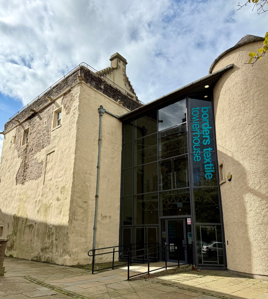 Rear view (the south) of the building, with a modern entrance to the museum made largely of glass..