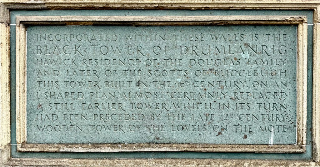 Plaque on the outside wall stating that the Black Tower of Drumlanrig is incorporated within the walls. It says it is an L-plan structure that replaced an earlier tower.