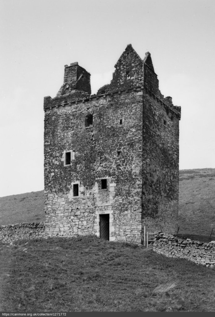 Black and white image from Historic Environment Scotland, showing the front and east side. There is a doorway at ground level, but by this stage, the first-floor door had been partly blocked to create a window. There is no roof.